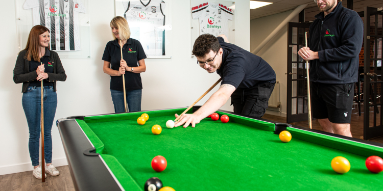 Some of the Dawleys team playing pool within their break room